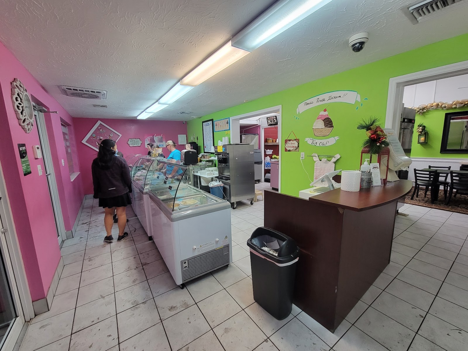 The bright pink and lime green interior of Pinecraft Ice Cream Shoppe with the ice cream case