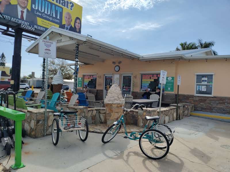 The yellow Pinecraft Ice Cream Shoppe storefront with teal cruiser bikes parked out front in Sarasota